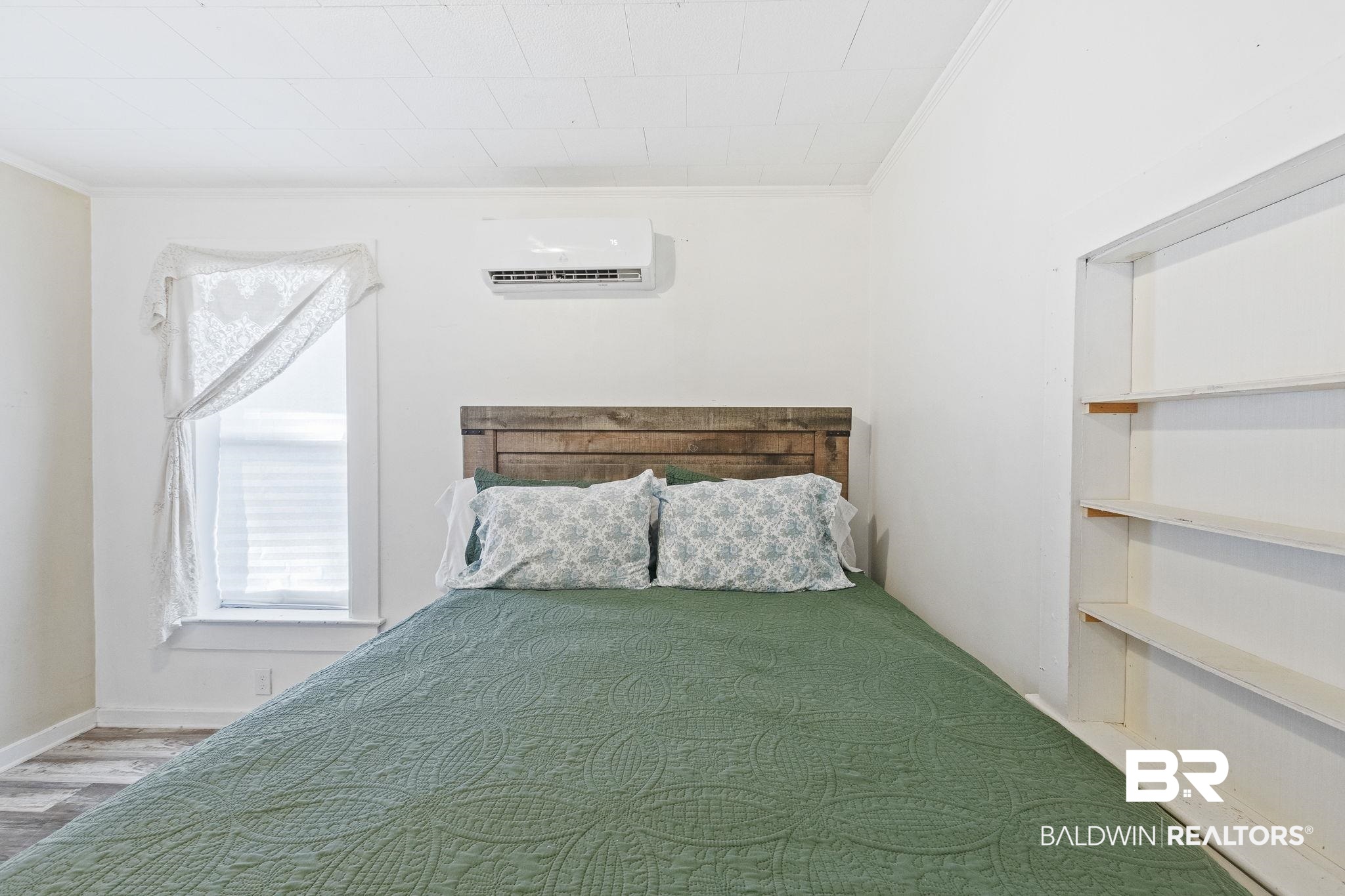 707 North Cedar Street Foley, AL 36535 - Photo 35 of 69 Unfurnished bedroom with crown molding, hardwood / wood-style floors, and a wall mounted air conditioner