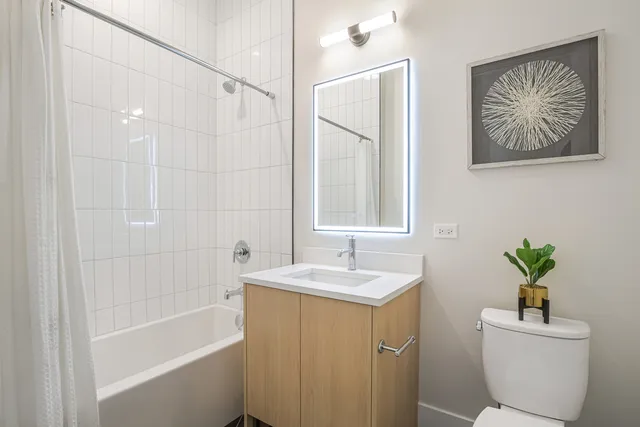 a bathroom with a sink a toilet a shower curtain and a bath tub