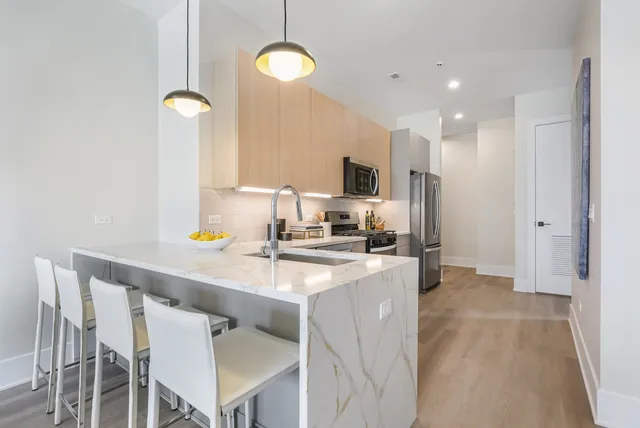 a kitchen with kitchen island a stove a sink and a refrigerator