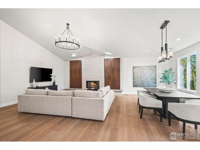 a living room with furniture a flat screen tv and a table