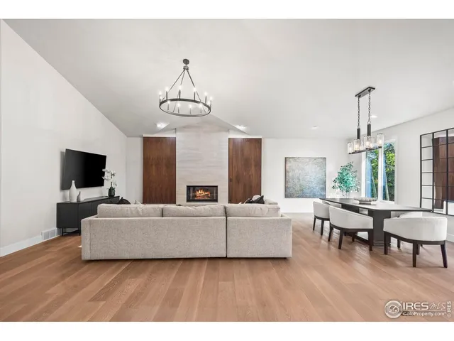 a living room with furniture a flat screen tv and a large window