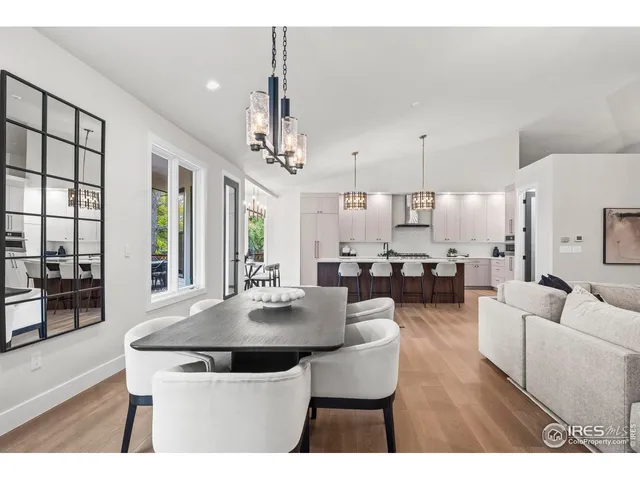 a living room with furniture a dining table and a large window