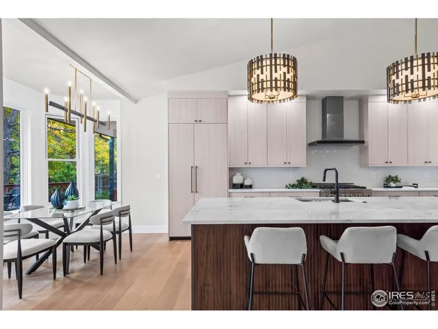 a kitchen with a dining table chairs and white cabinets