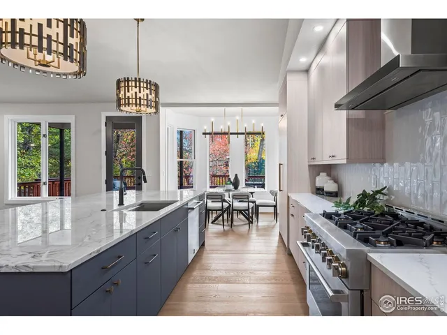 a kitchen with kitchen island granite countertop a table chairs sink and cabinets