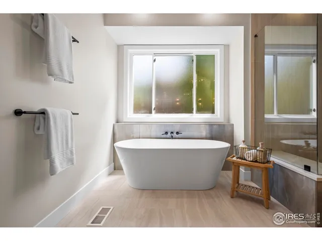 a bathroom with a tub a sink and mirror