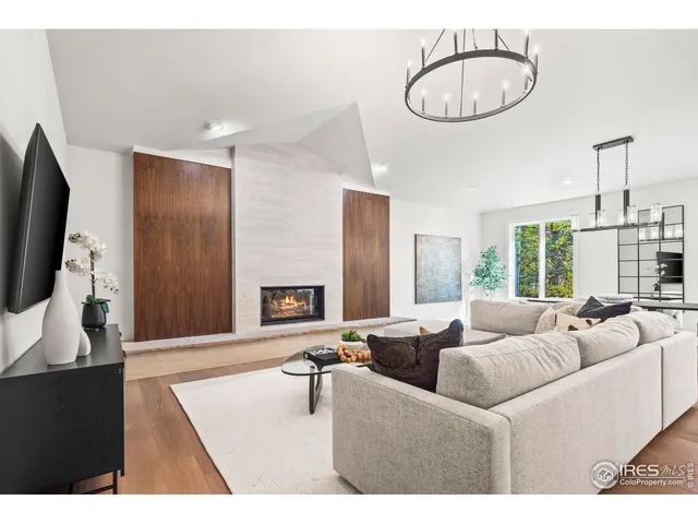 a living room with furniture a flat screen tv and a large window