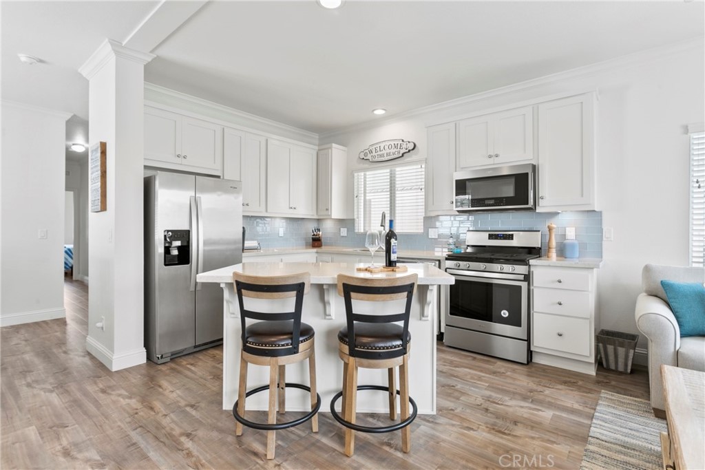 108 Bay Drive San Clemente, CA 92672 - Photo 14 of 28 a kitchen with stainless steel appliances a stove a sink refrigerator and a refrigerator with wooden floor