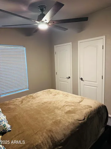 a bedroom with a bed and a ceiling fan