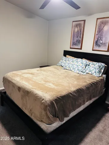 a bed sitting in a bedroom next to a wall painting