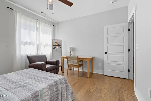 a bedroom with a bed and a bookshelf with wooden floor