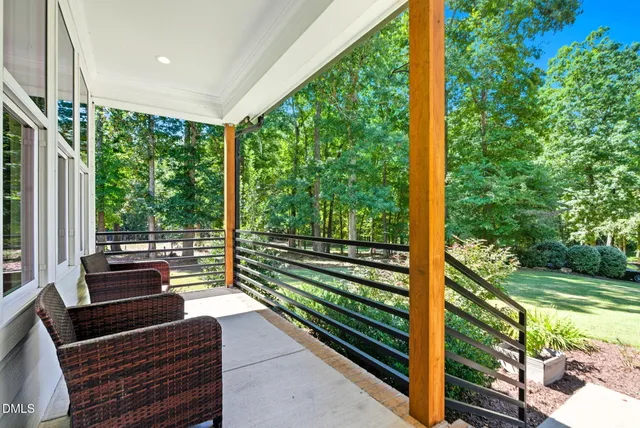 a sitting area with chairs in front of a yard