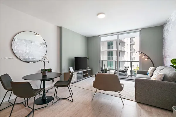 a living room with furniture a table and a large window