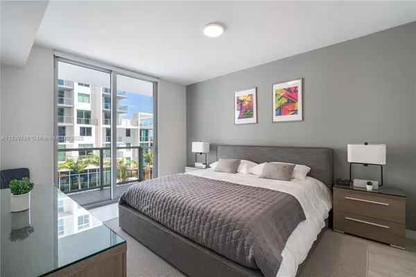 a bedroom with a balcony a bed and a large window