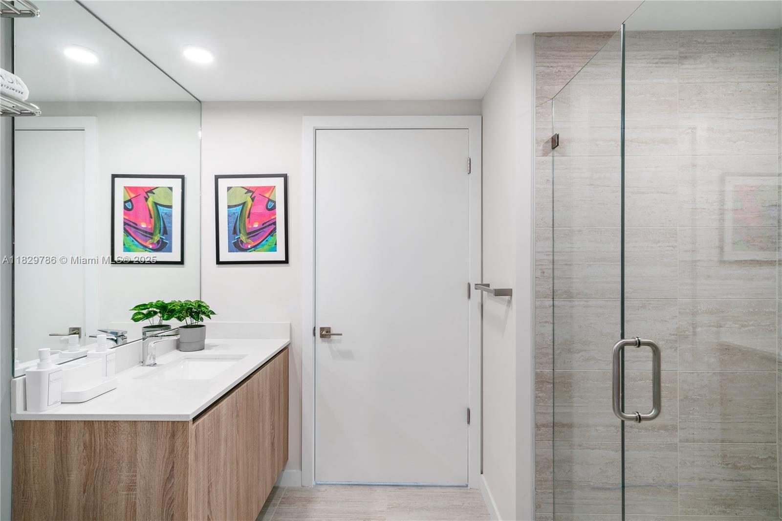 3900 Biscayne Boulevard, Unit S818 Miami, FL 33137 - Photo 6 of 32 a bathroom with a sink a mirror and a shower