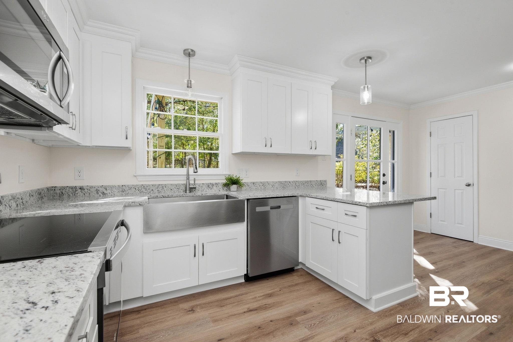 814 Nassau Drive Mobile, AL 36608 - Photo 2 of 44 Kitchen with stainless steel appliances, light stone counters, decorative light fixtures, a peninsula, and white cabinets