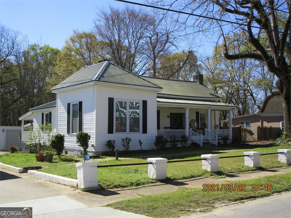 a front view of a house with a yard and potted plants