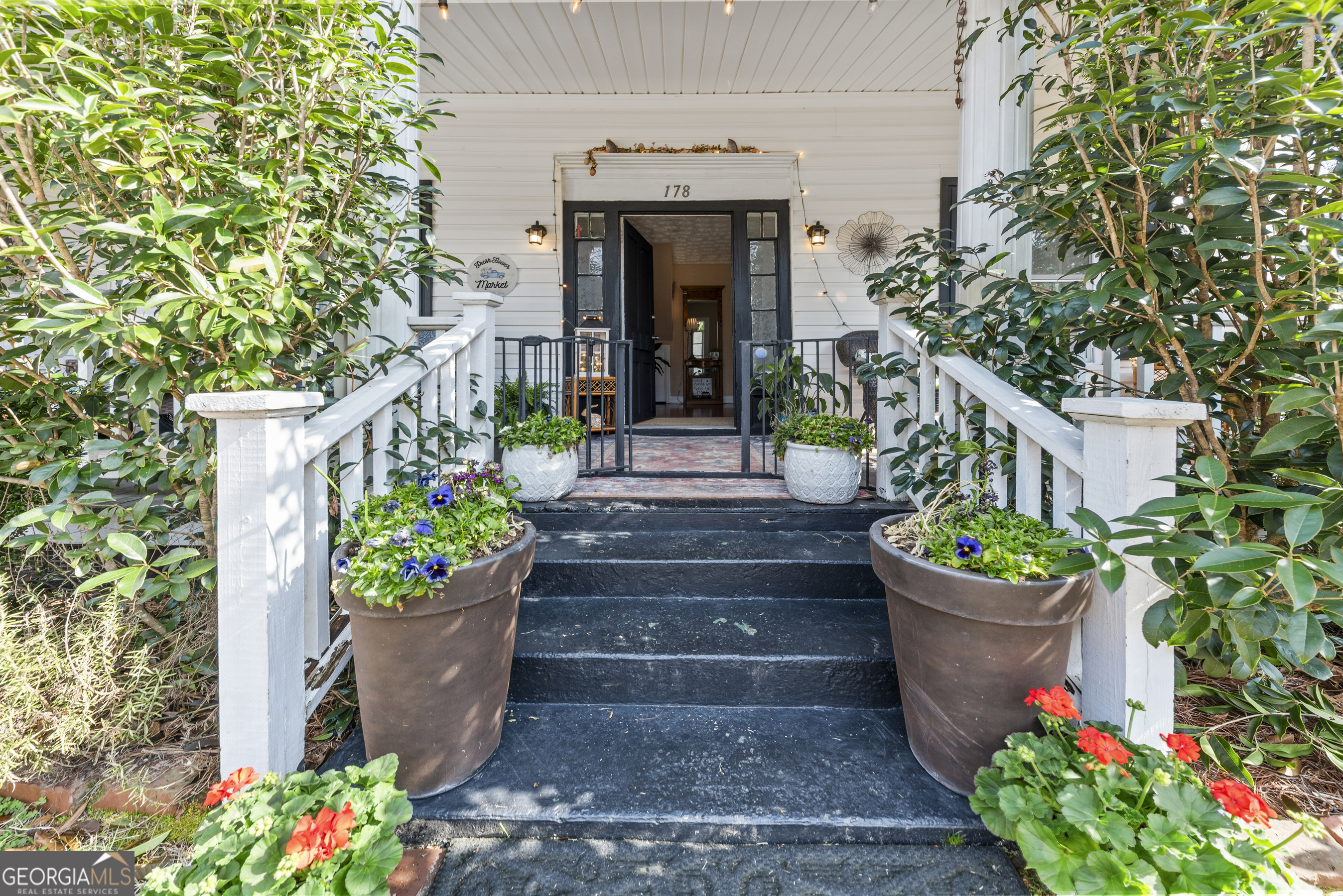 178 Fairplay Street Rutledge, GA 30663 - Photo 15 of 54 a front view of a house with lots of flowers and trees