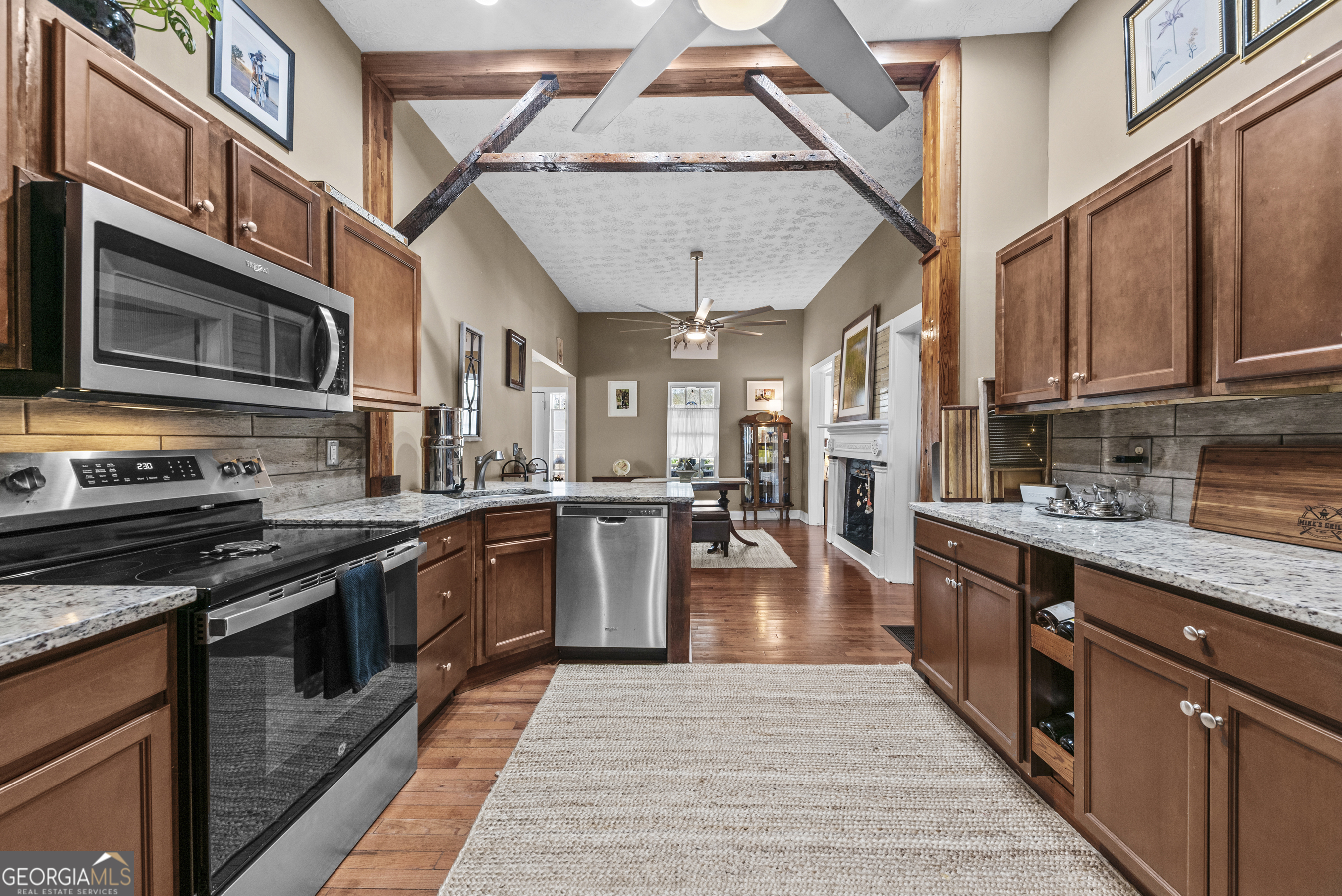178 Fairplay Street Rutledge, GA 30663 - Photo 26 of 54 a kitchen with stainless steel appliances granite countertop a stove top oven a sink dishwasher a dining table and chairs with wooden floor