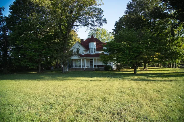 a front view of a house with a yard and trees