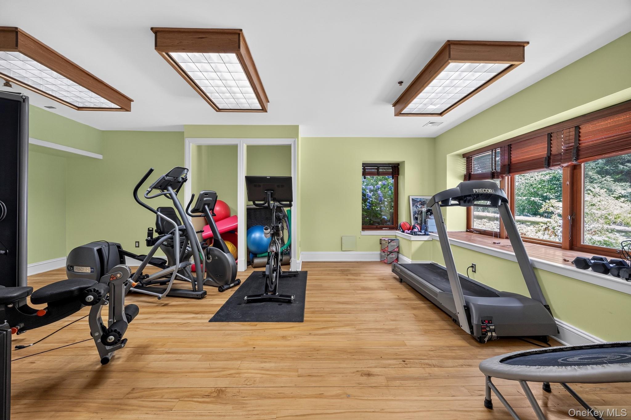 23 Inningwood Road Ossining, NY 10562 - Photo 33 of 50 Dedicated fitness area with wood-finish flooring, two large recessed ceiling light fixtures, built-in window seating, and multiple windows with wood blinds