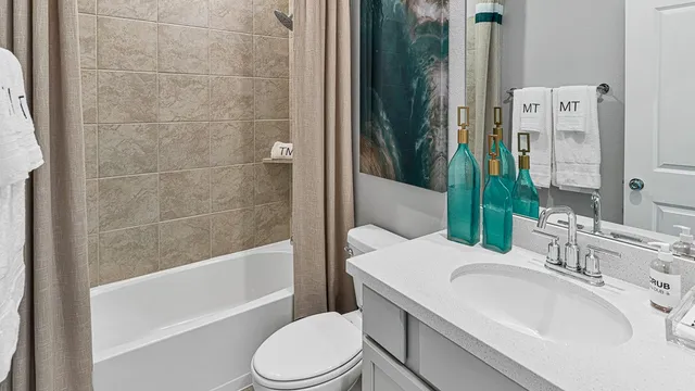 a kitchen with stainless steel appliances granite countertop white cabinets a stove a sink and a wooden floor