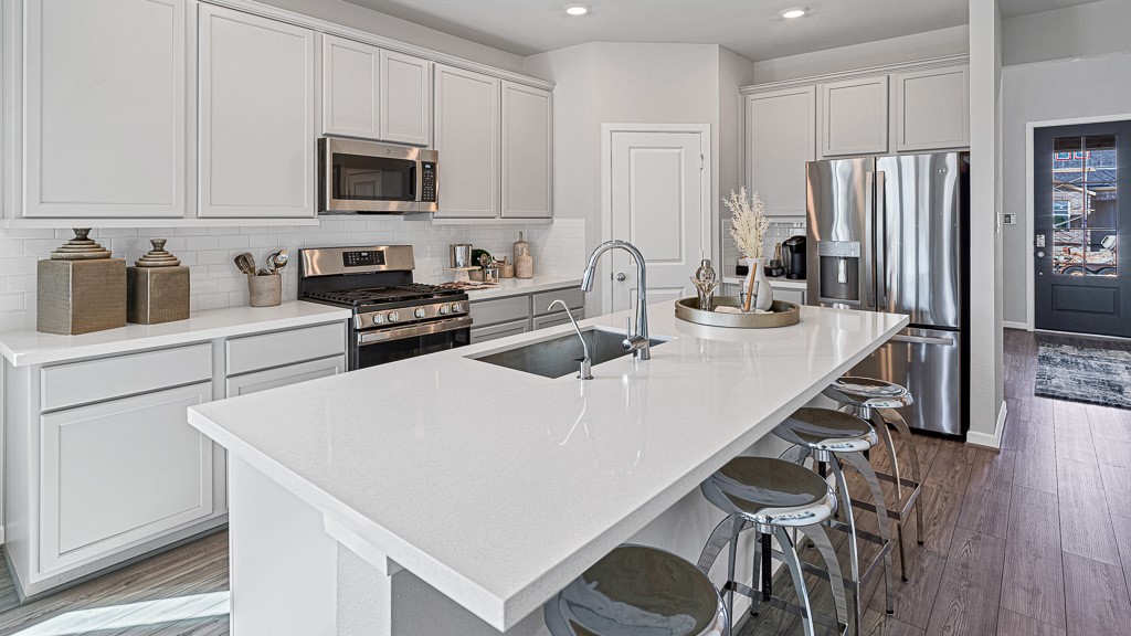 1202 Buffalo Run Tomball, TX 77375 - Photo 12 of 45 a kitchen with stainless steel appliances a stove a sink a microwave and a refrigerator