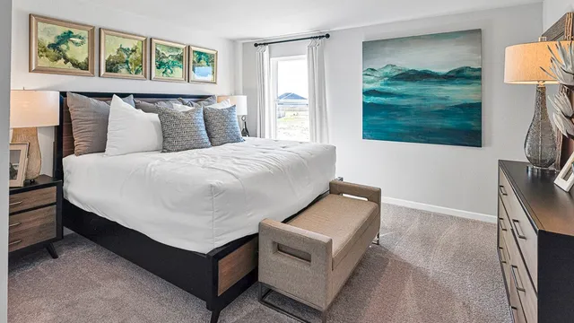 a bedroom with a bed and a painting on the wall