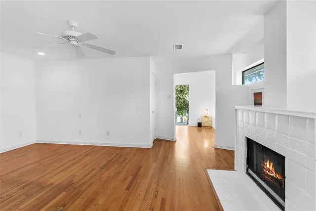 a view of empty room with wooden floor and fireplace