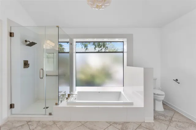 a bathroom with a glass shower door and a window