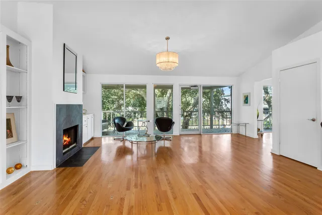 a view of a livingroom with furniture a fireplace and wooden floor