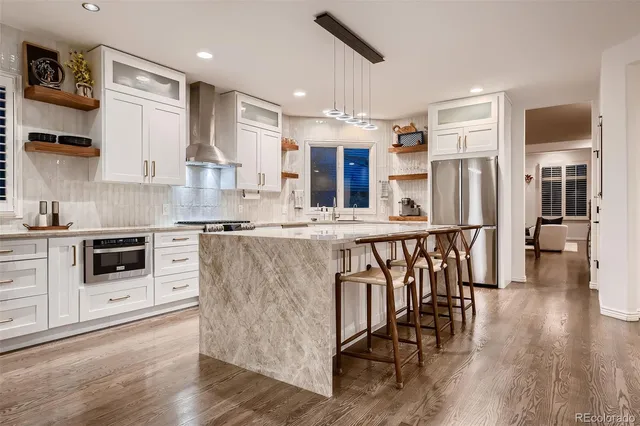 a bathroom with a granite countertop sink a mirror and shower