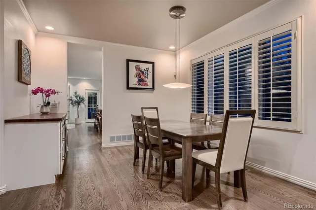 a kitchen with stainless steel appliances kitchen island granite countertop a stove a sink a refrigerator and white cabinets with wooden floor