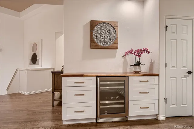a living room with stainless steel appliances furniture a fireplace and a kitchen view