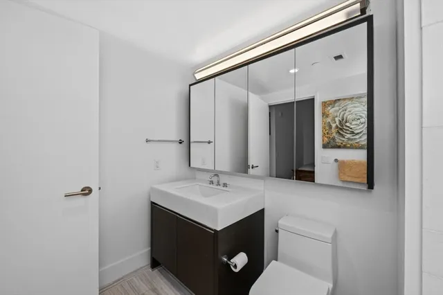 a bathroom with a sink and mirror with toilet