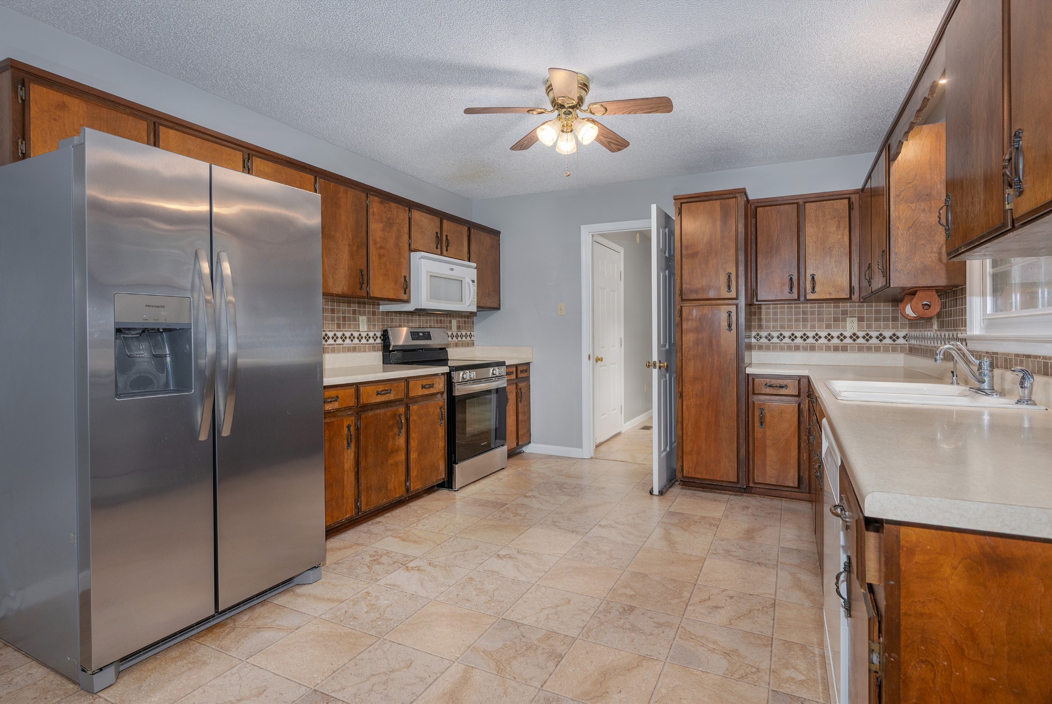 5665 Old Salem Road Rockvale, TN 37153 - Photo 30 of 41 a kitchen with stainless steel appliances granite countertop a refrigerator a sink a stove with white cabinets