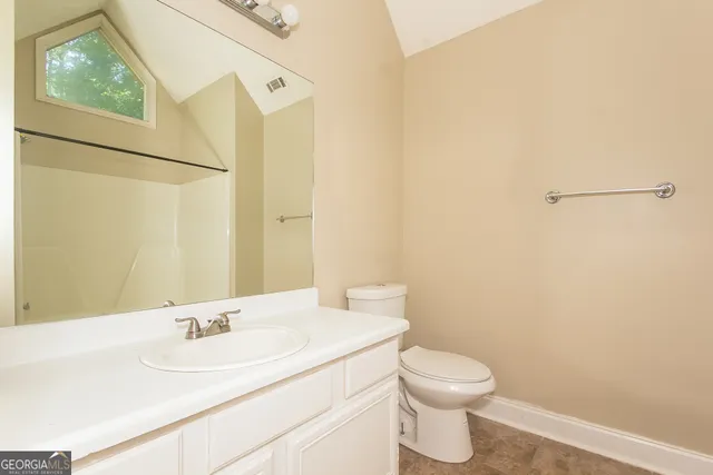 a bathroom with a sink a toilet and a mirror
