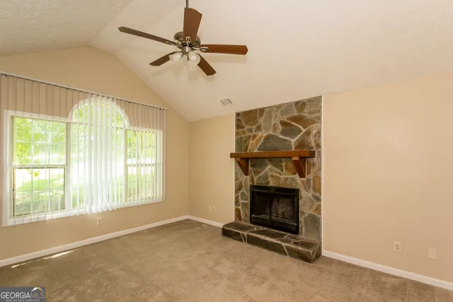 a living room with a fireplace and a ceiling fan