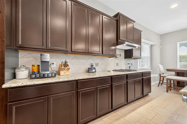 a kitchen with stainless steel appliances granite countertop a sink stove and cabinets