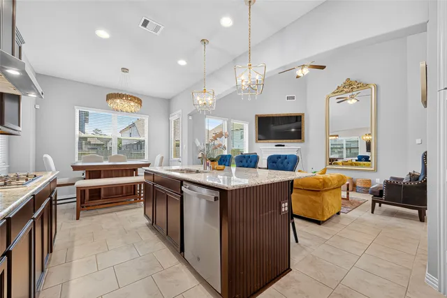 a large kitchen with kitchen island granite countertop a stove and a view of living room