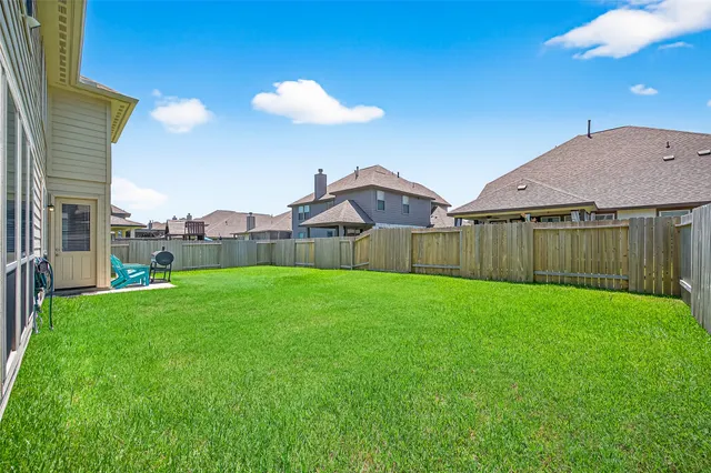 a view of a backyard with table and chairs and wooden fence