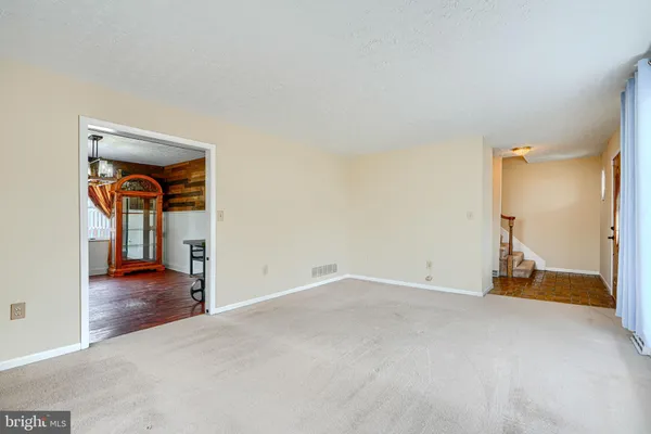 a view of a livingroom with wooden floor and stairs
