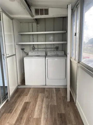 a utility room with wooden floor washer and dryer
