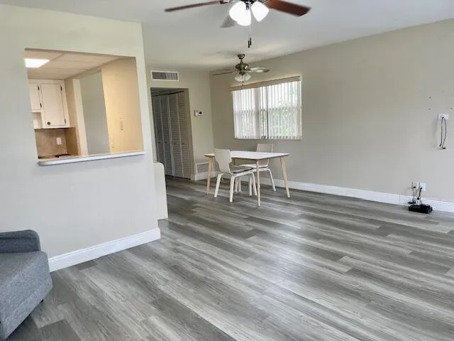 a view of a room with wooden floor and furniture