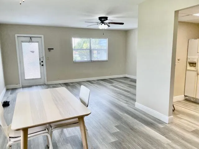 a view of a livingroom with wooden floor and a ceiling fan