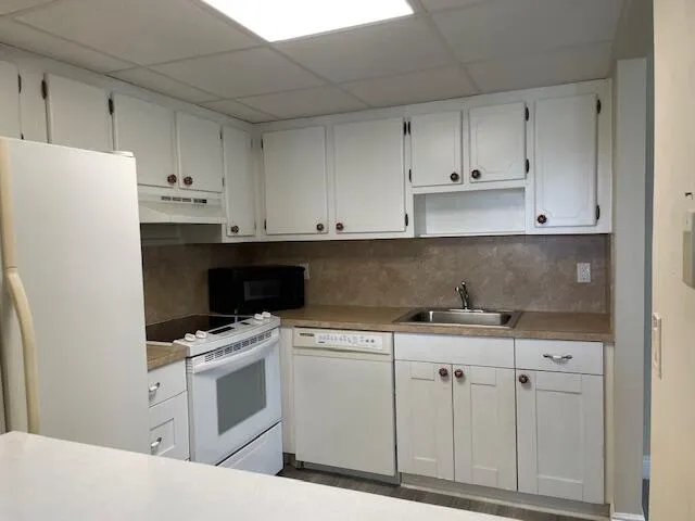 a kitchen with white cabinets and white appliances
