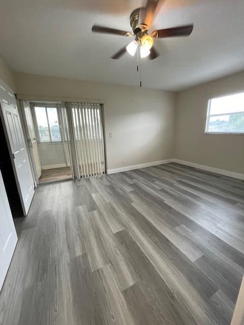 323 Tuscany Lane, Unit F Delray Beach, FL 33446 - Photo 10 of 12 an empty room with wooden floor fan and windows