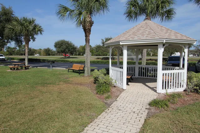 a view of entrance gate of a house and cars parked