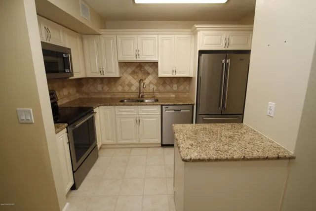 a kitchen with white cabinets and stainless steel appliances