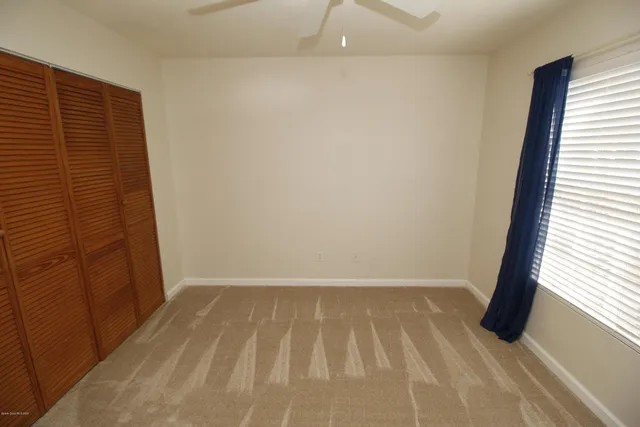 a view of hallway with a window and a bathroom