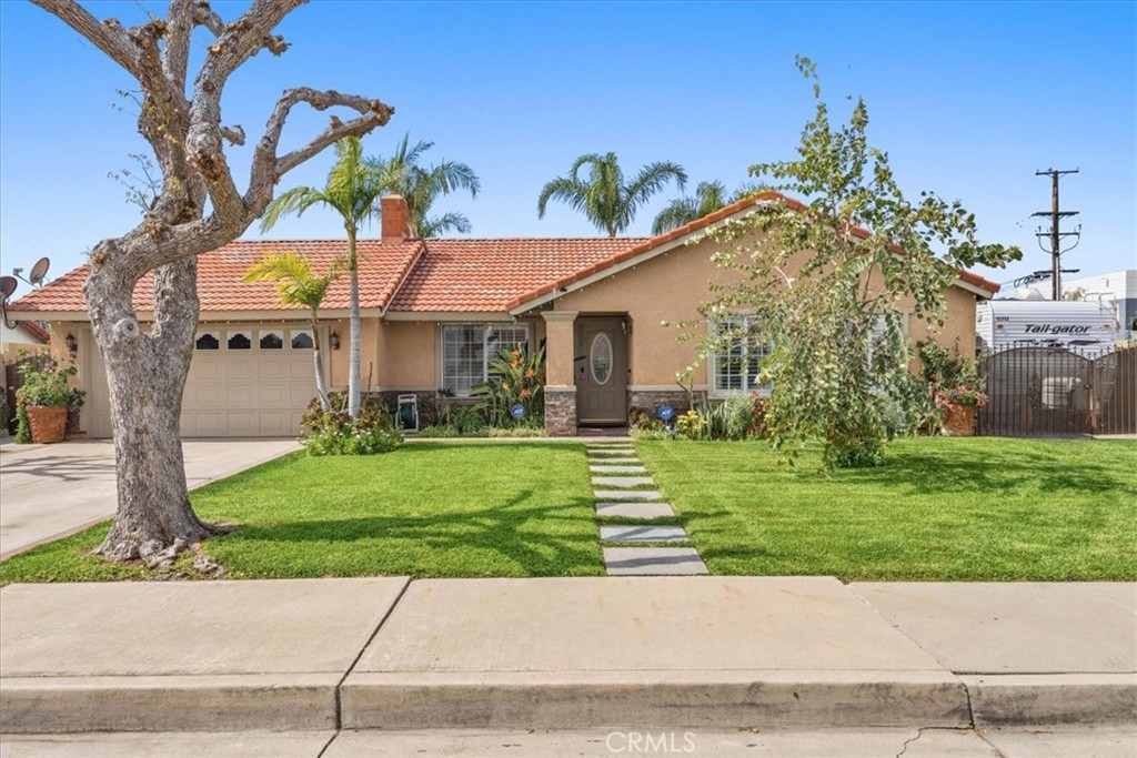 506 South Althea Avenue Rialto, CA 92376 - Photo 1 of 36 a view of a white house next to a yard with big trees and plants